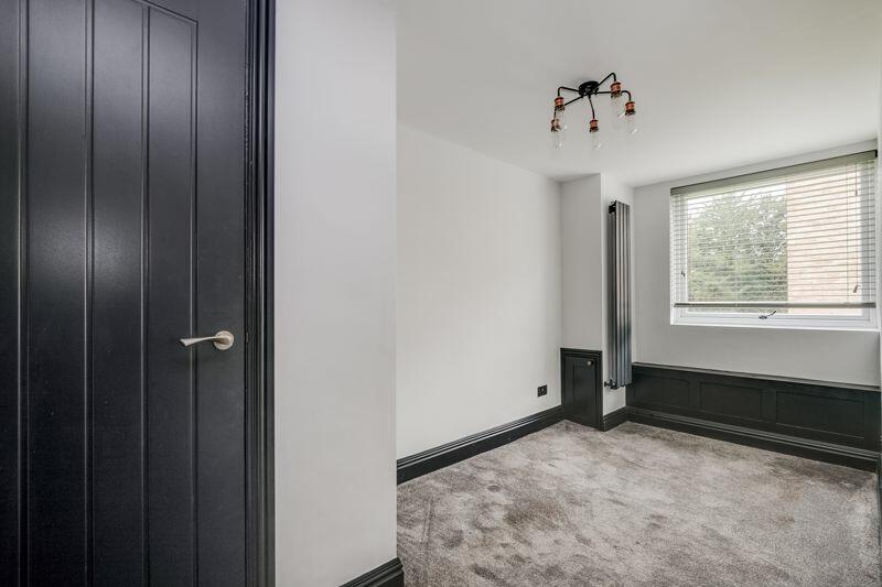 Bedroom with black panelled door and dado rail