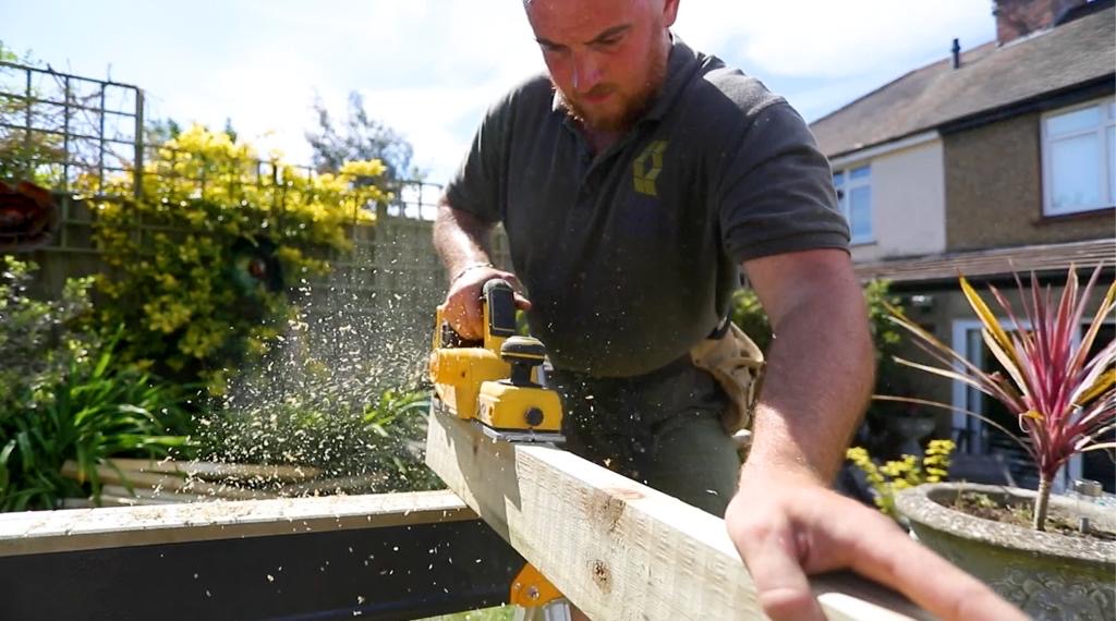 Sean planing a timber joist with a cordless planer