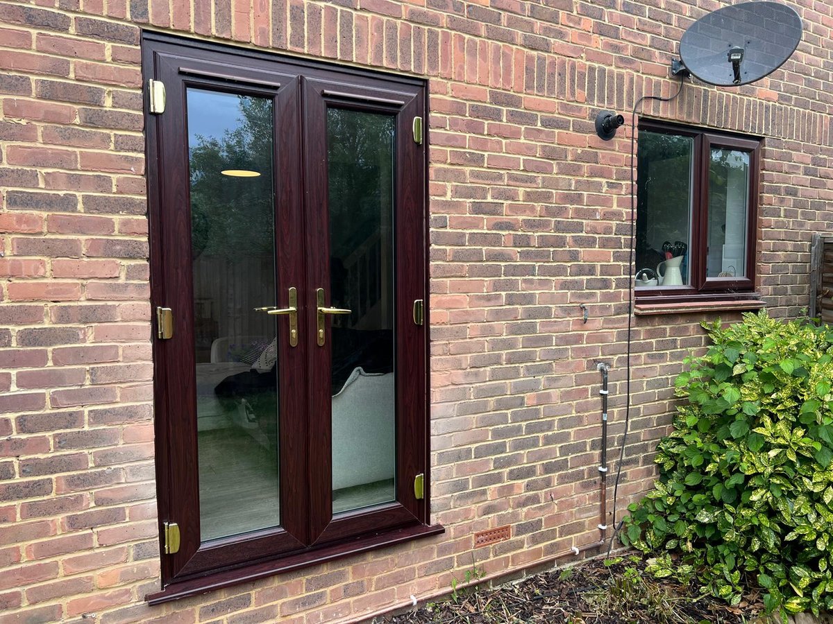 New rosewood PVC French doors installed in a brick wall in a North Holmwood home, replacing an existing PVC window
