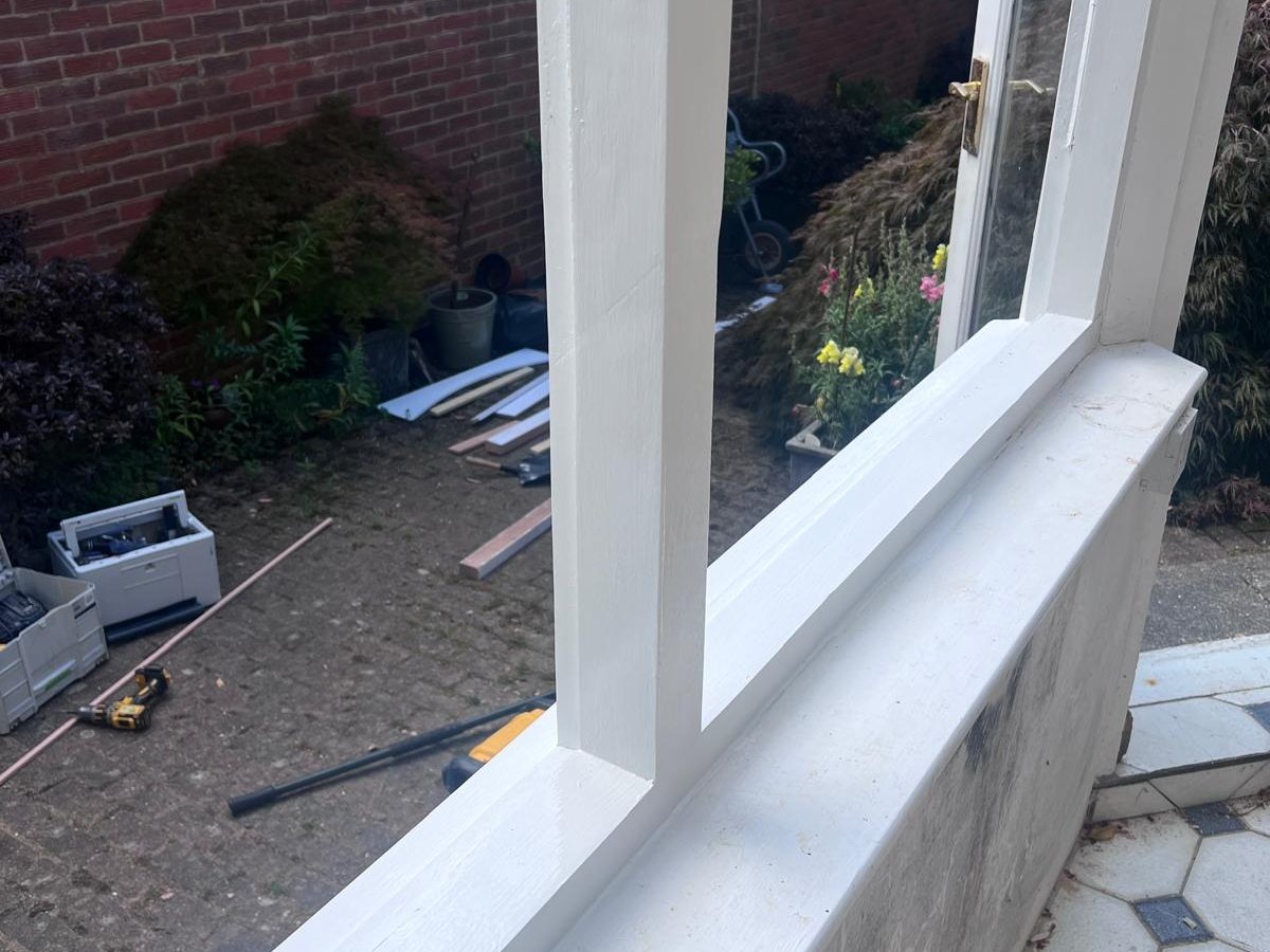 Restored timber conservatory frame painted white after bespoke hardwood joinery repair